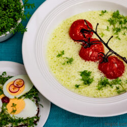 Kresseschaumsuppe mit Rösttomaten und eine Scheibe Pumpernickel belegt mit Eischeiben und Radieschen